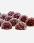 Sugar-coated purple gummies in a half-dome shape on white background