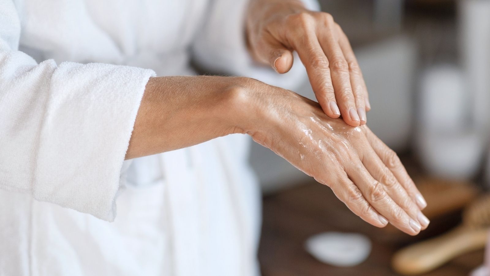 Close-up of hands applying moisturizing skincare cream, suggesting hydration, relief, and self-care