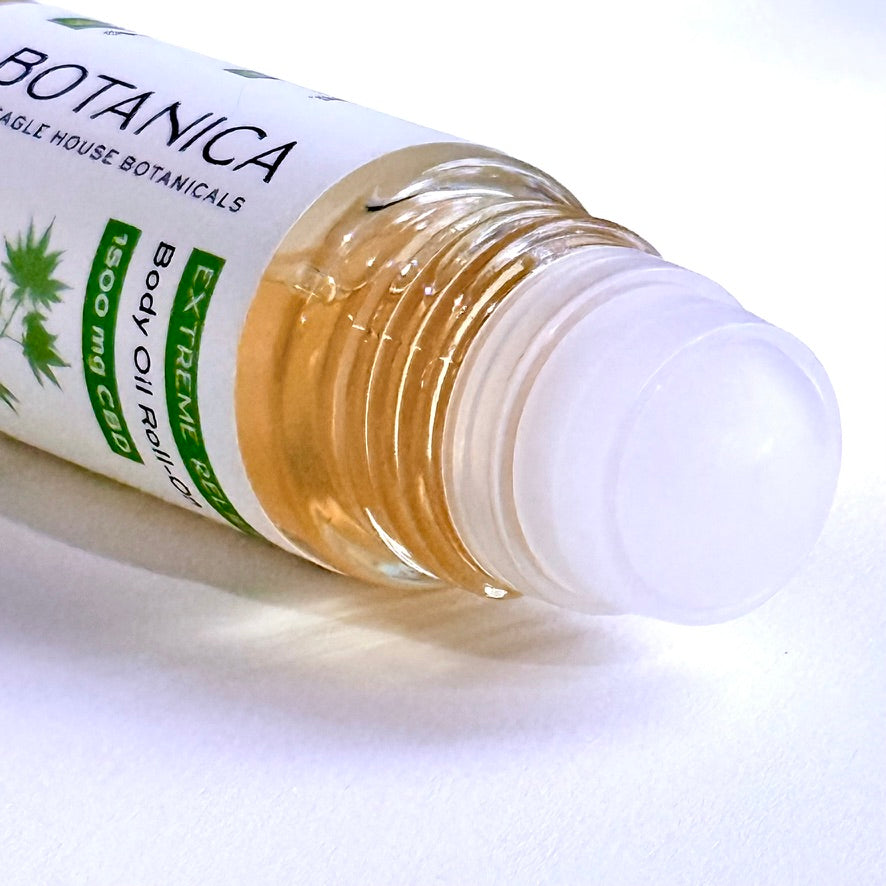 Close-up of Botanica Extreme Relief CBD body oil roll-on applicator showing glass bottle and smooth roller ball
