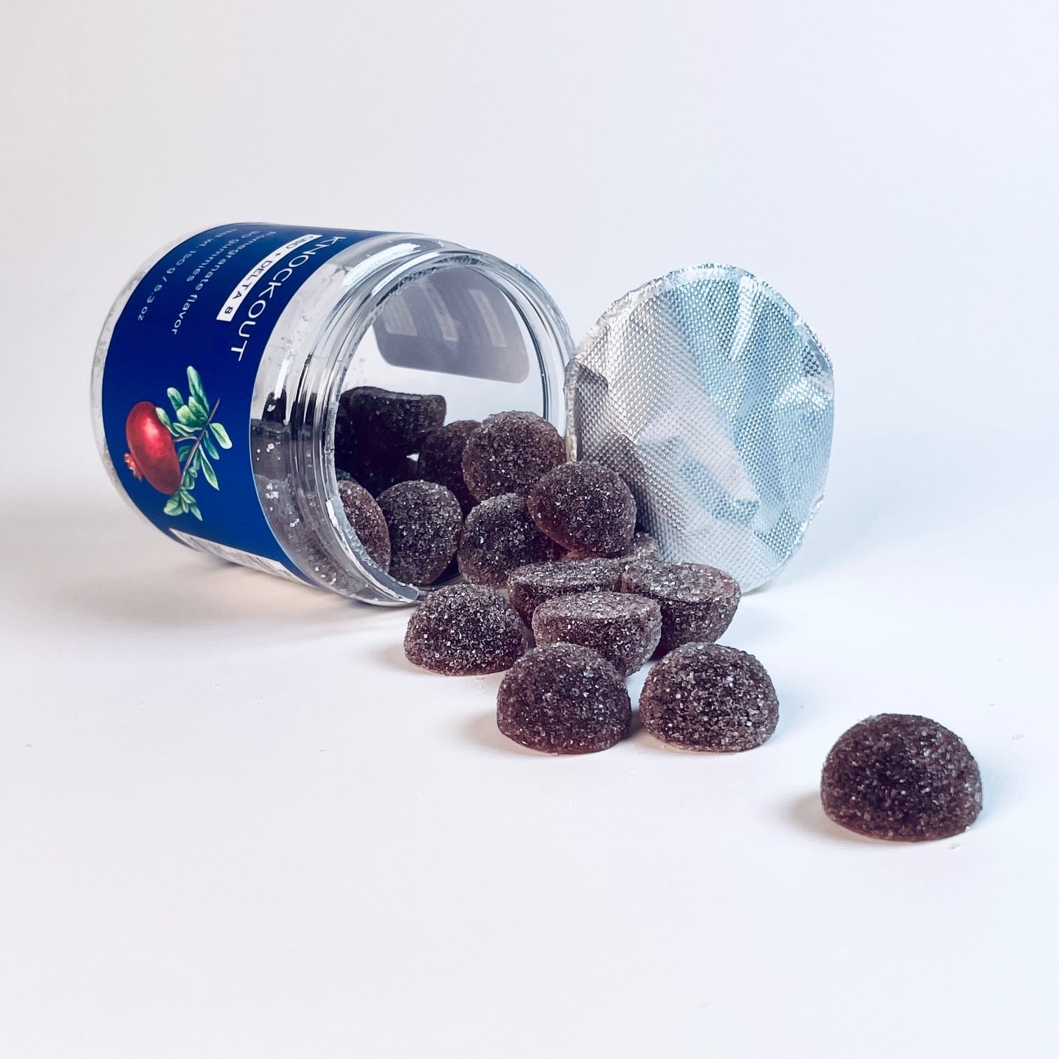 Jar of dark berry gummies spilled on a white surface, representing nighttime wellness and sleep support supplements