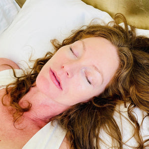 Close-up of a woman sleeping peacefully on a pillow with natural light