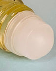 Close-up of a roll-on applicator with golden CBD oil in a glass bottle.