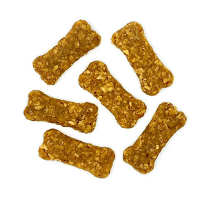 Six bone-shaped peanut butter dog treats on a white background.